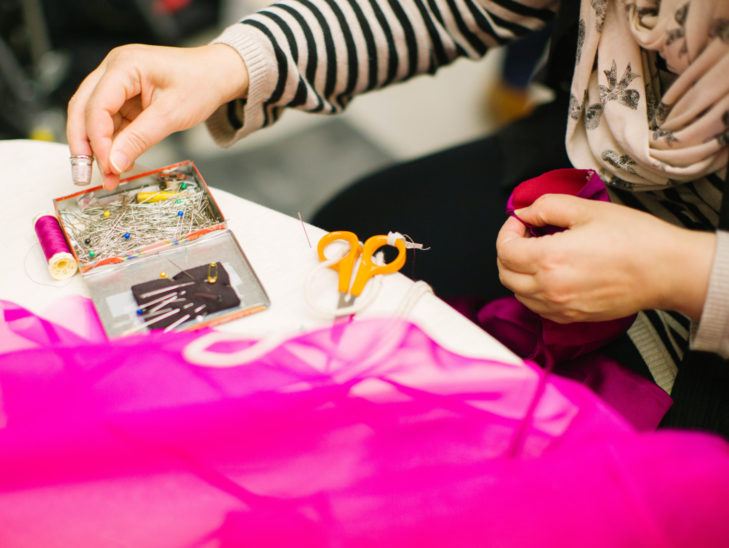 A person sewing a piece of fabric.