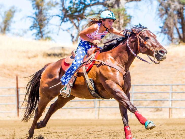 A camper on a horse getting ready for a jump.