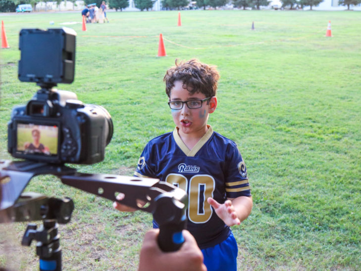 A camper standing in front of a camera recording an interview.