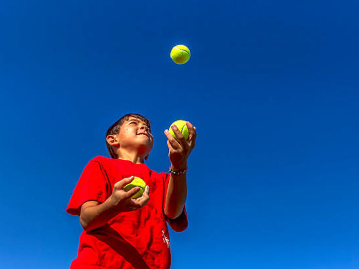 A camper learning how to juggle.