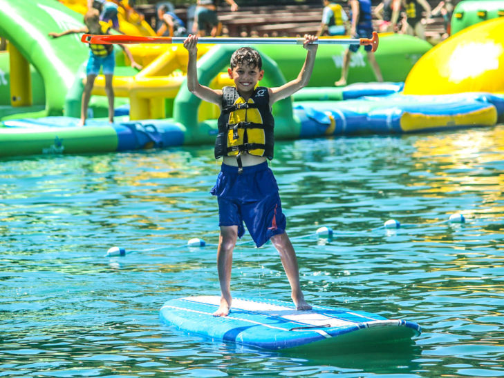 Campers paddleboarding in the lake.