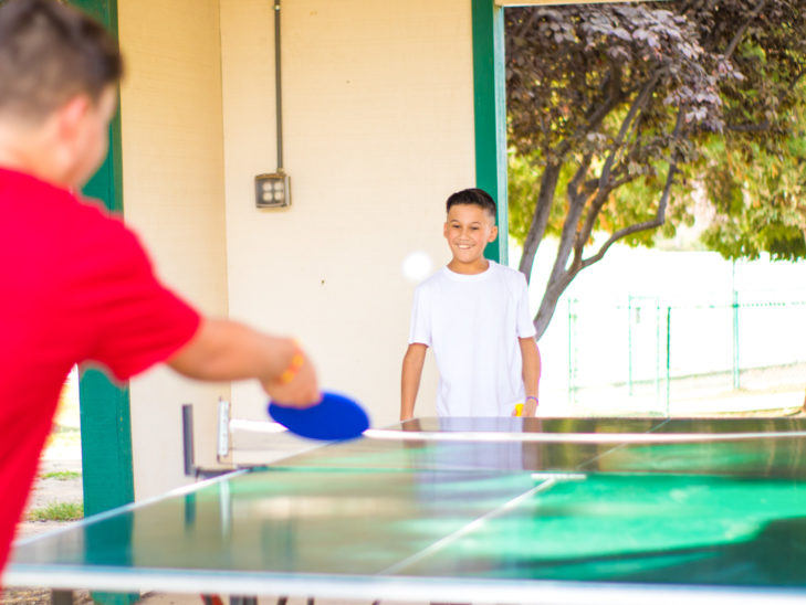 Two campers playing ping pong.