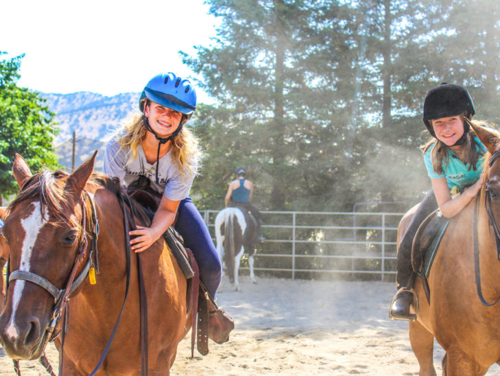 Campers riding horses.
