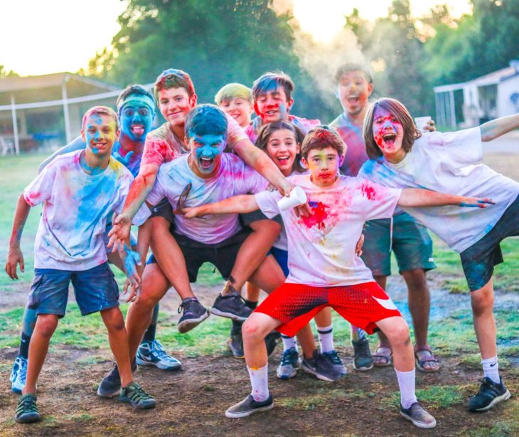 Campers with colorful dust on their clothes having a good time.