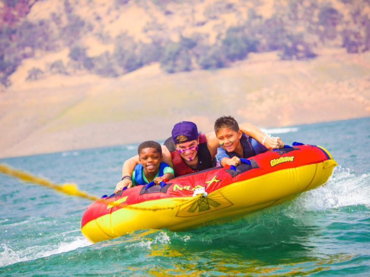 Campers having fun tubing on a lake.