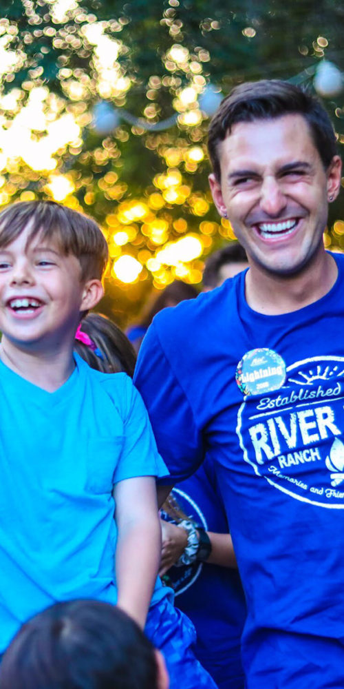 A camper and a counselor laughing